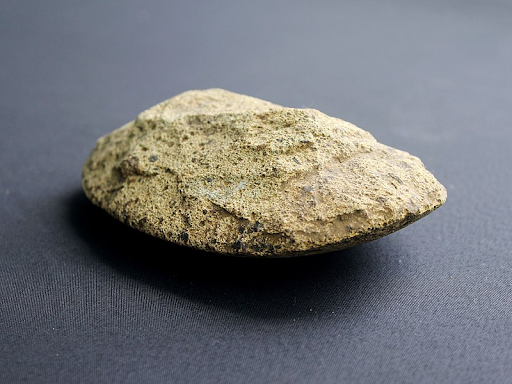 kapak genggam yang terbuat dari batu, berukuran kecil, masih sederhana, dan belum diasah.